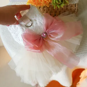 Detail of pet wedding dress featuring lace floral patterns and a large pink organza bow