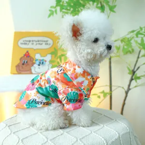 Detail van een kleurrijk huisdierenshirt met opstaande kraag bij een witte Bichon