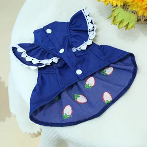Détail d'une robe pour animal en jean bleu avec dentelle blanche et fraises brodées