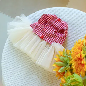 Detail of red gingham dog dress featuring a tulle tutu skirt and heart style buttons