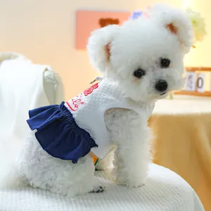 Détail de robe pour animaux en tissu gaufré avec broderie rouge fraise