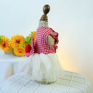 Detail of red checkered pet dress with white tulle skirt and red bow on a pet mannequin