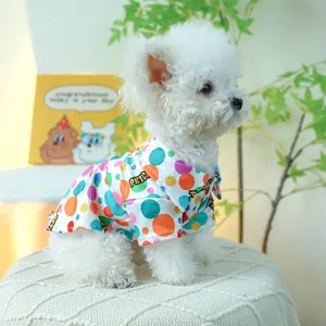 Detail van kleurrijk polkadots huisdierenshirt op een witte hond met reverskraag