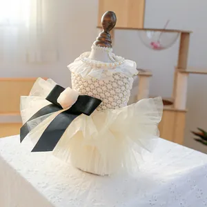Detailed view of white crochet pet wedding dress with pearl collar and large black satin bow