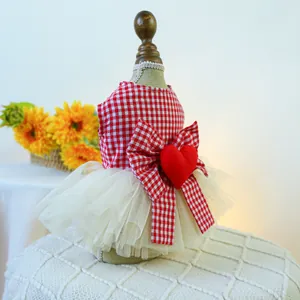 Detail of red gingham pet dress with large bow, plush heart, and layered tulle skirt