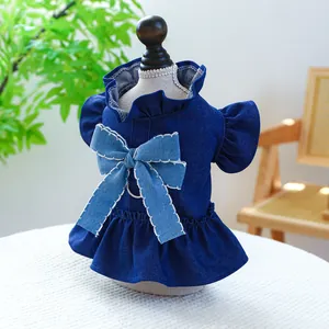 Détail d'une robe en jean pour animaux avec bords volantés et un nœud en denim bleu