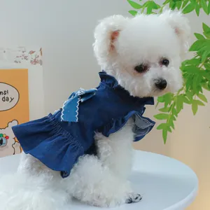 Detail of dark blue denim pet dress with bright blue bow and ruffled edges for dogs