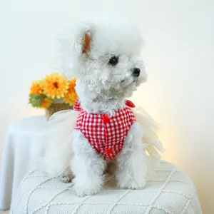 Detail of red and white checkered pet dress with fluffy tulle skirt on a white dog