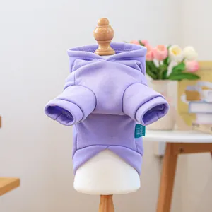 Detail view of purple pet hoodie with brand label on soft fabric and cozy background