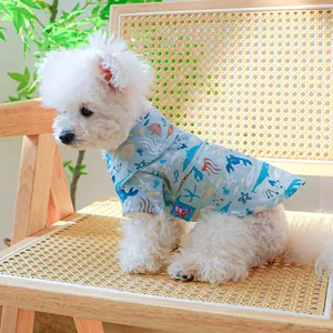 Detail van zomerhemd voor huisdieren met oceaanprint op een hond op een rotan stoel