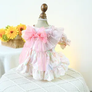 Detail of pink floral pet dress featuring a large mesh bow and delicate lace hemline