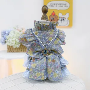 Detailed view of light blue floral pet dress with layered lace and pearl necklace