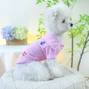 Détail du polo pour chien rose avec broderie nautique porté par un Bichon Frisé