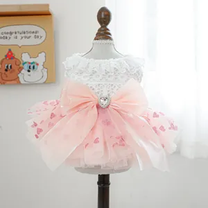Pink pet princess dress with lace trim and heart rhinestone bow on a display stand