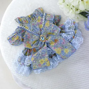 Detail of pet floral lace dress with blue bow, pearls, and gemstone for dogs and cats
