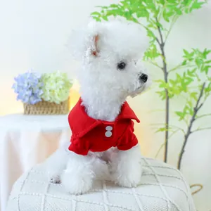 Détail d'un polo rouge pour chien avec boutons blancs et col classique sur petit chien