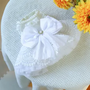 Détail de la robe de mariée blanche pour chien avec collier en perles et nœud en maille