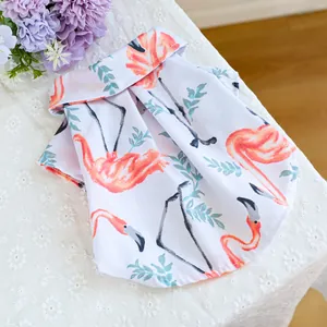 Detail van huisdier shirt met oranje flamingo en groene bladeren op een witte ondergrond