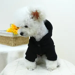 Detail of a black pet hoodie with snap buttons and hood worn by a white Bichon dog
