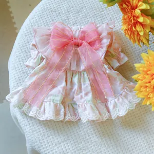 Detail of pink floral pet dress featuring a large sheer bow with golden stitched edges