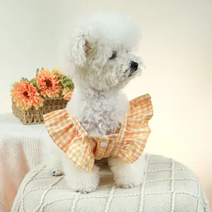 Détail d'une robe vichy jaune pour animal avec volants doux et bouton pression blanc