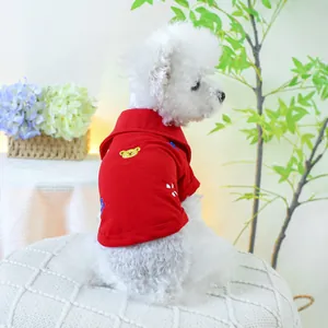 Détail d'un polo rouge pour animaux avec broderie ours jaune et motifs floraux