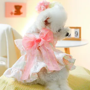 Detail of pink floral pet dress featuring a large bow and delicate white lace trim
