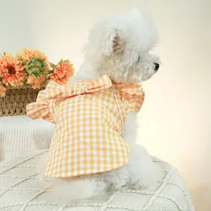 Détail de la robe pour chien à carreaux jaunes avec nœud et manches à volants sur un chien