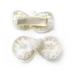 Detail of lace bow pet hair clip with star embroidery and pearl heart accent