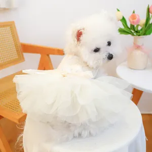 Back view detail of a white ruffled pet tutu dress worn by a small fluffy white dog