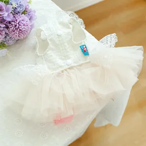 Detail of white lace pet wedding dress featuring layered tulle skirt and snap buttons