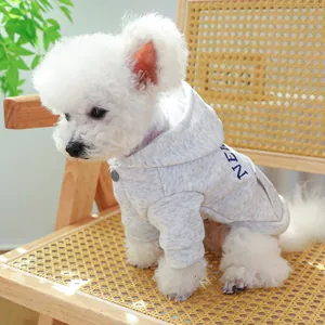Detail of grey pet hoodie with NEW text and button collar on a small dog sitting