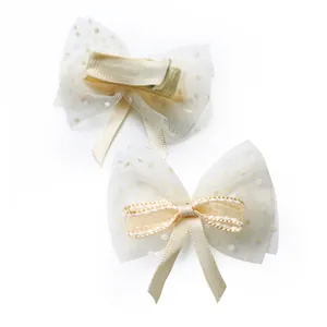 Detail showing two cream ribbon bows with mesh and a safe fully wrapped duckbill clip