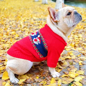 Close-up of red dog Christmas sweater with reindeer patterns and white pom-poms details