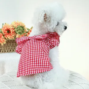 Détail de la robe d'été pour chien à carreaux rouges avec volants sur chien blanc