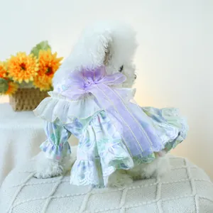 Close-up of pet summer dress featuring floral patterns and a large purple organza bow