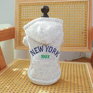 Grey pet hoodie with New York letter print on a vintage chair for small dogs and cats