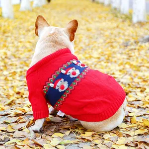 Close-up of red knit dog sweater with festive reindeer patterns and soft yarn texture