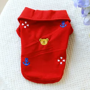 Détail d'un polo rouge pour animaux avec broderie ours et ancre sur tissu en coton
