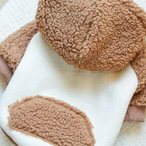 Détail du tissu doux en laine d'agneau marron et blanc sur ce sweat pour chien