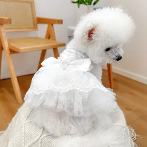 Detail of white pet wedding dress with lace lace trim, satin bow and pearl accents