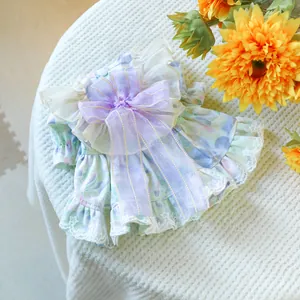Detail of floral pet dress with lavender bow and intricate lace embroidery trim