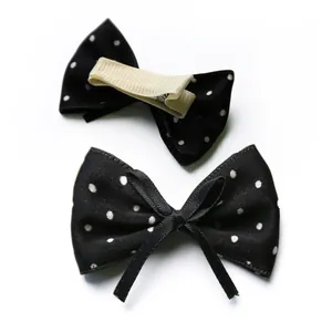 Detailed front and back view of black polka dot bow hair clips for small dogs