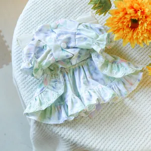Detailed close-up of floral pet dress with white lace trim and button back closure