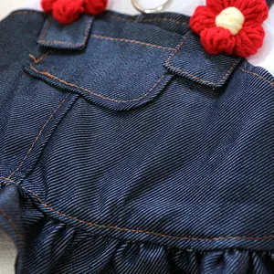 Détail d'une robe en jean pour chien avec fleurs au crochet et coutures jaunes