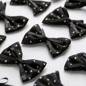 Detailed view of handmade black polka dot bow hair clips for dogs on wood background