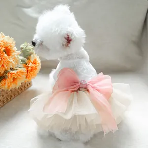 Detailed lace dog wedding dress featuring fluffy tulle skirt and pink bow with heart jewel