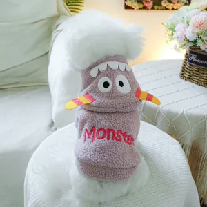 Détail du sweat à capuche rose pour animaux avec broderie monstre et pompon blanc doux