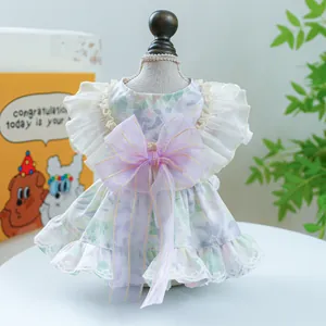 Detail of floral pet dress with lace edges and a large purple translucent bow accent