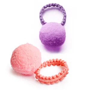 Close-up of pink and purple plush ball hair ties with elastic wavy texture for pets